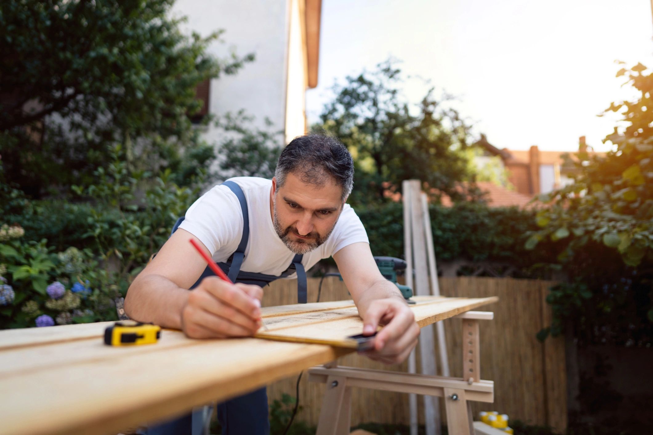 Carpenter measuring wood for a project