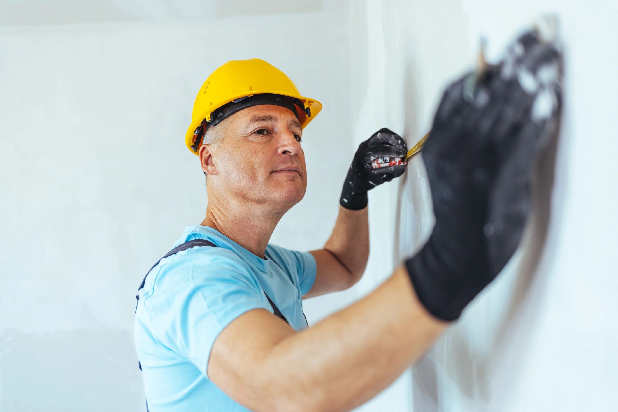 Contractor measuring a wall during an interior remodel